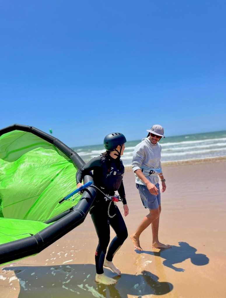 Kitesurf instructor and student walking on Essaouira beach with Duotone kite