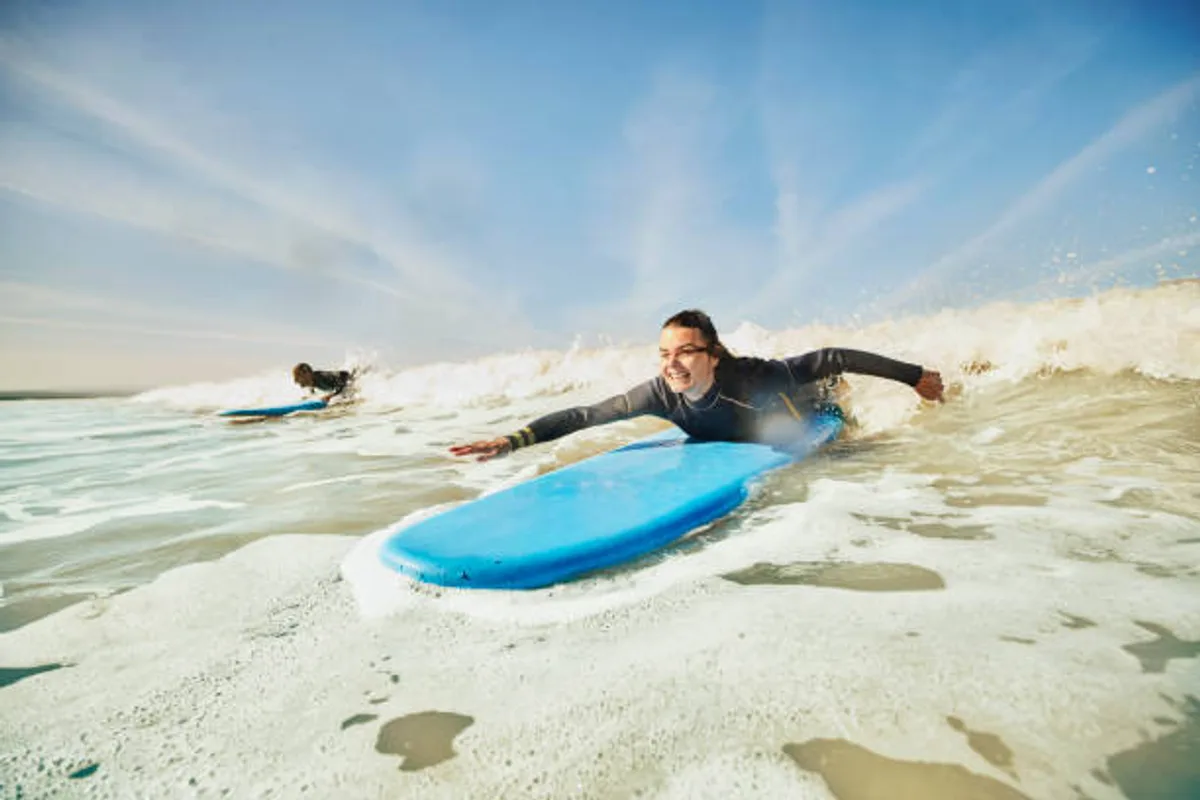 7 days surf camp Essaouira — beginner catching whitewater on a blue board