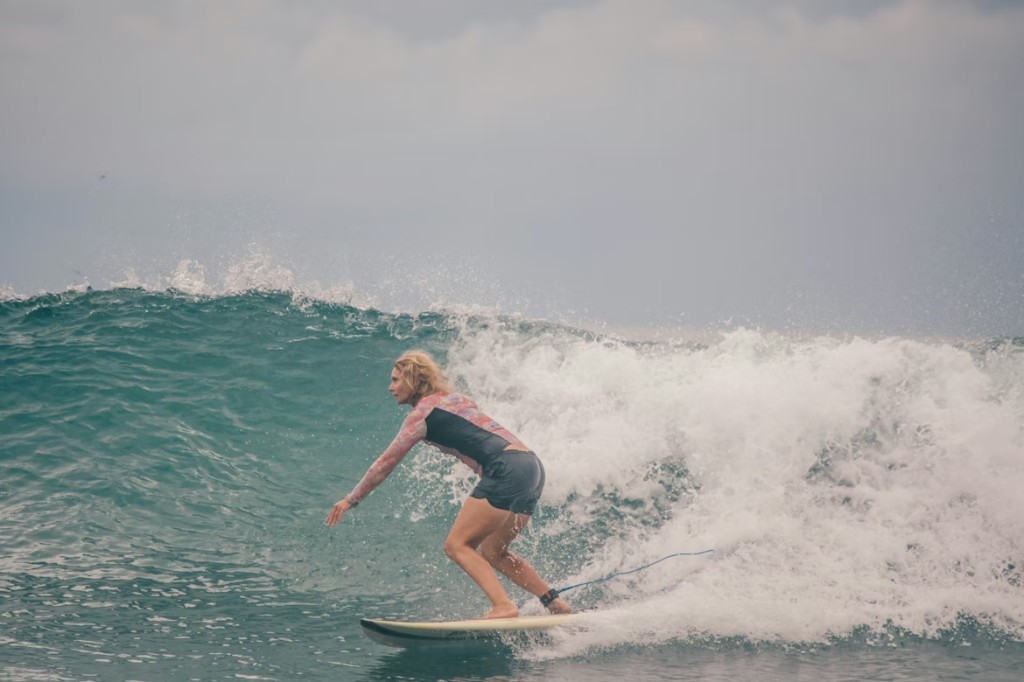 Woman surfing a breaking Atlantic wave off the Essaouira coast, Morocco