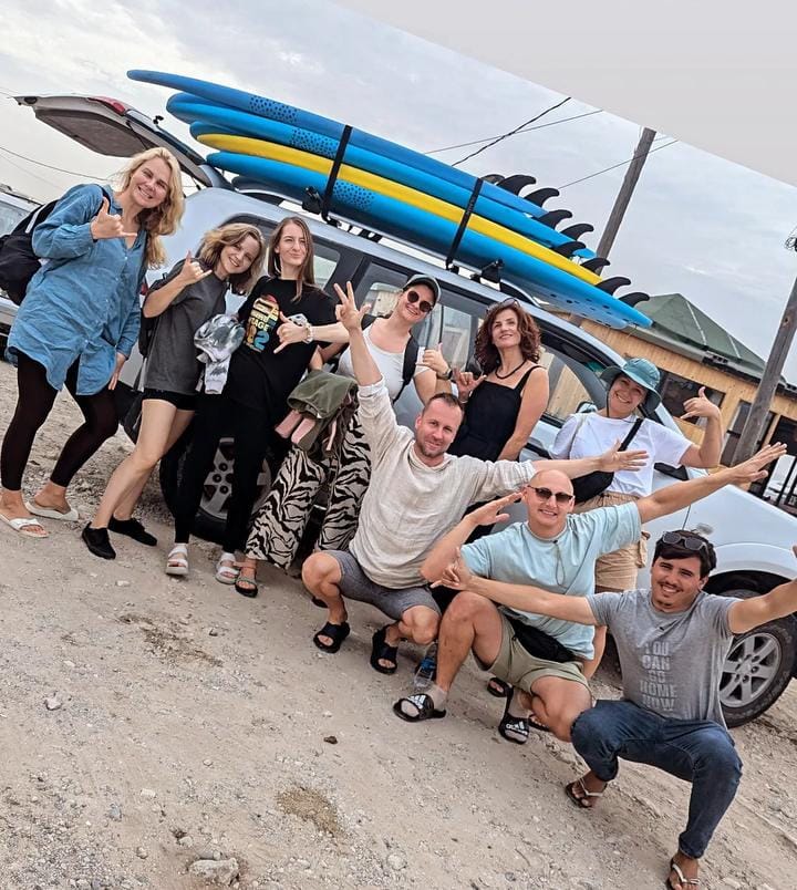 Family surf holiday Essaouira — group with surfboards on roof rack before a beach session