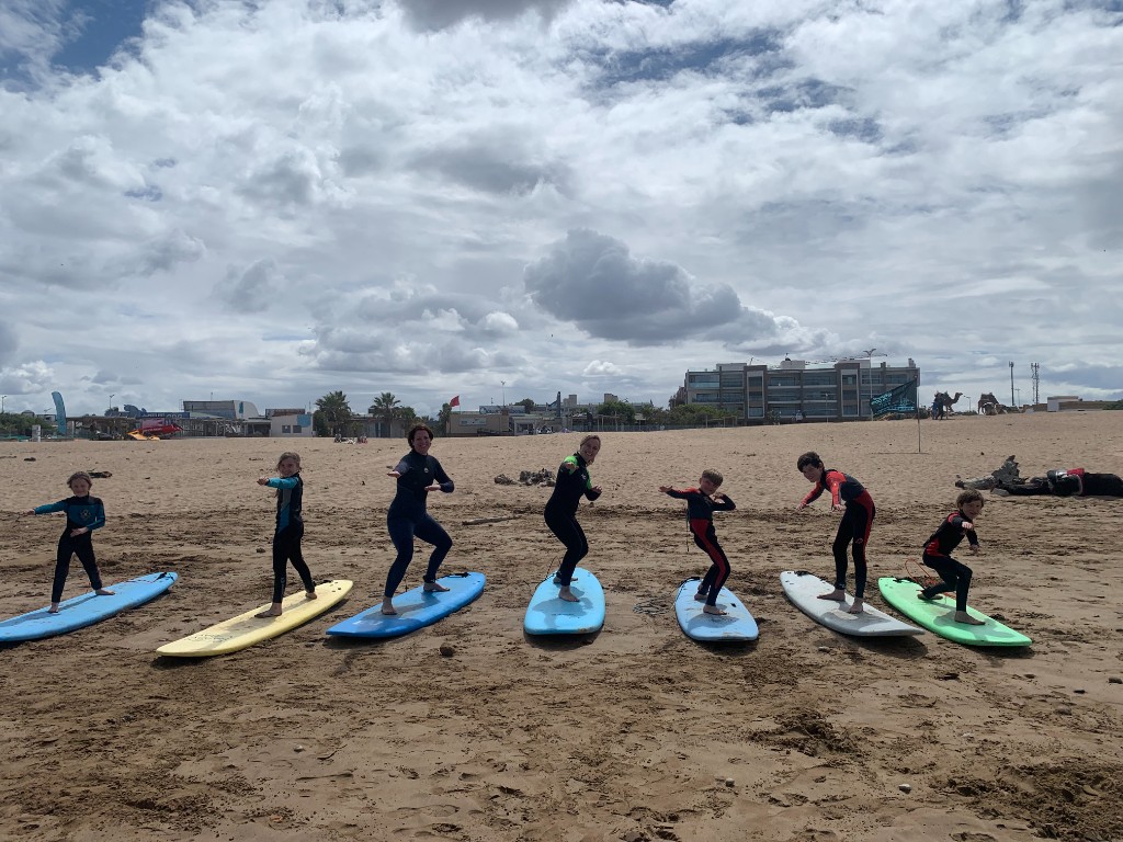 Surf students practicing pop-up stance on boards on Essaouira beach
