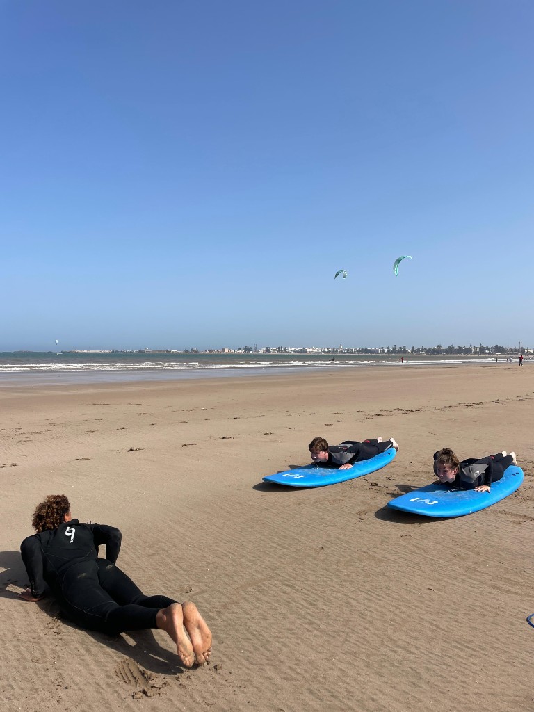 Surf coaching on Essaouira beach — pop-up practice on the sand before entering the water
