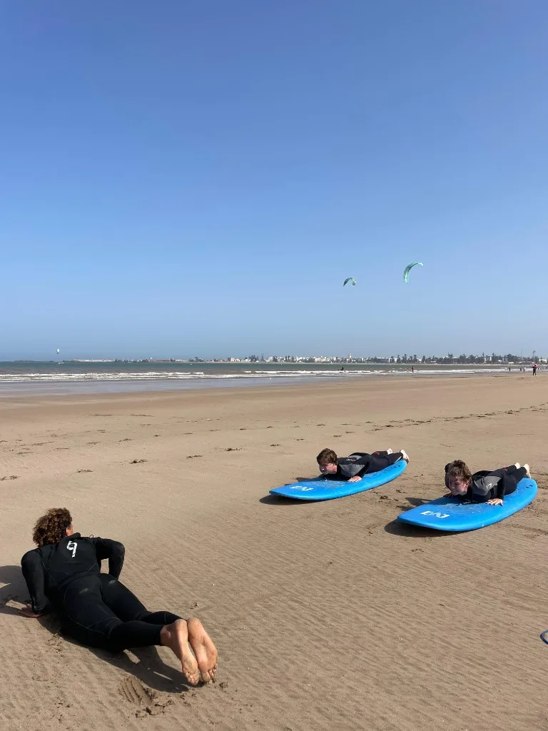 Surf coaching on Essaouira beach — pop-up practice on the sand before entering the water