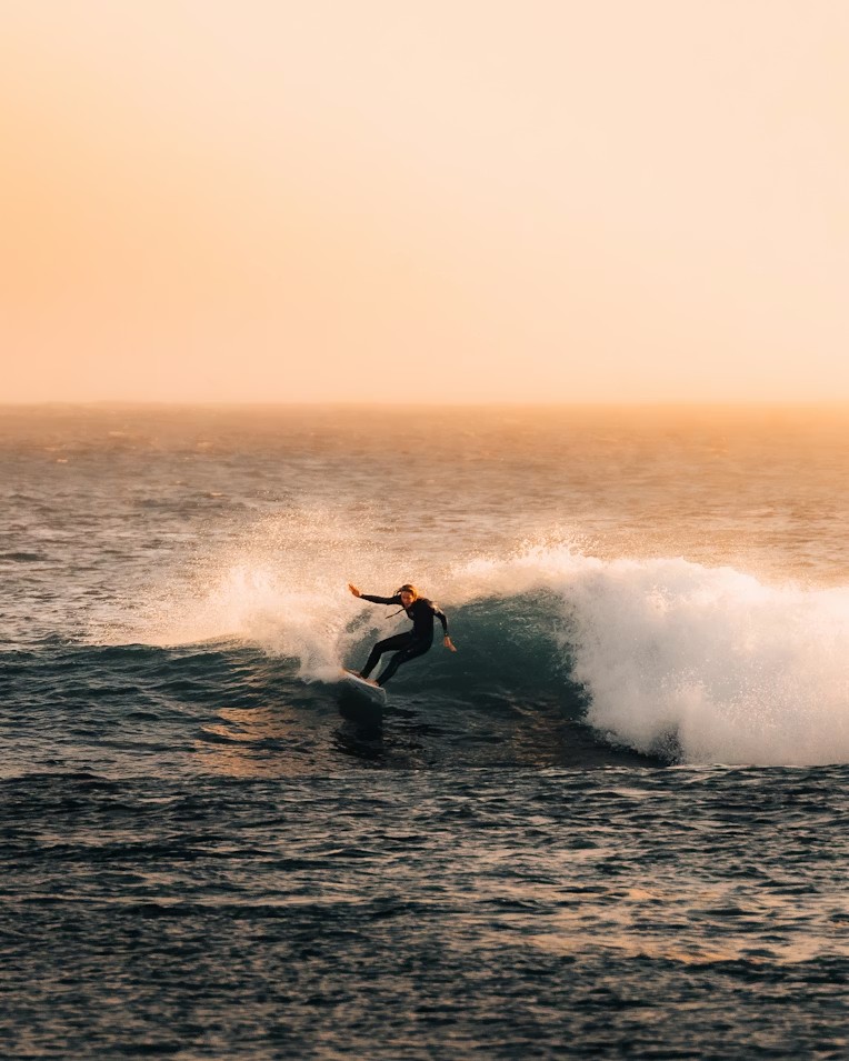 Surfer carving at golden hour on Atlantic wave Essaouira