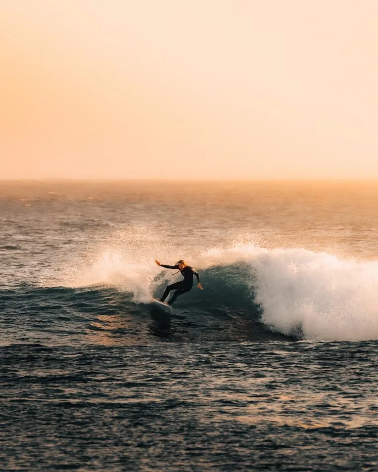 Surfer carving at golden hour on Atlantic wave Essaouira