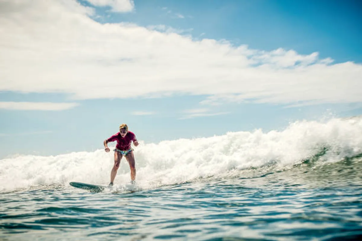 Surfcamp Essaouira — surfeuse sur une vague de l'Atlantique marocain
