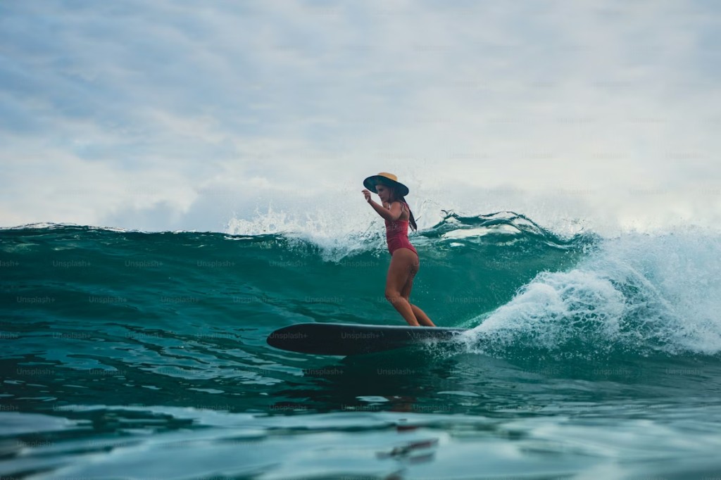 Surfer riding a turquoise wave at Essaouira Bay — beginner-friendly Atlantic beach break