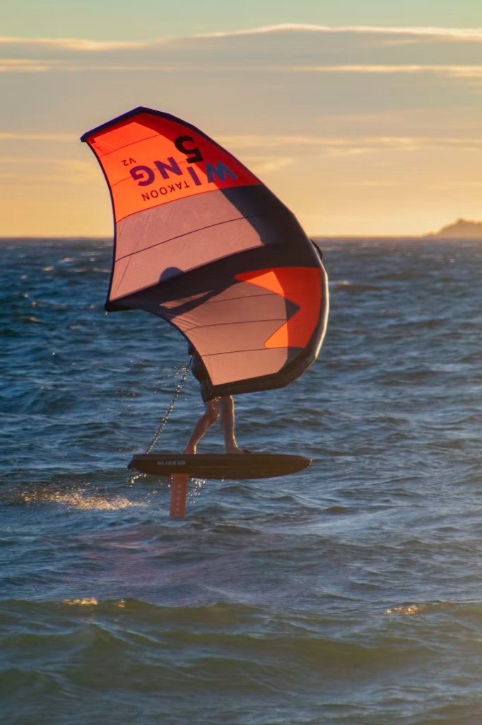 Wing foiler riding above the Atlantic at golden hour in Essaouira trade wind